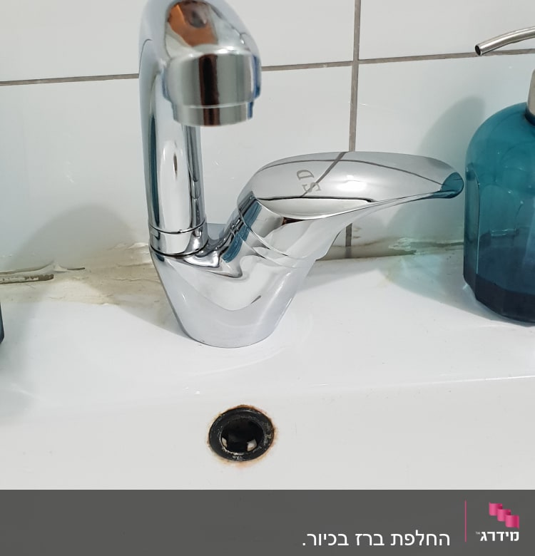 ברז כרום על כיור לבן עם ניקוז